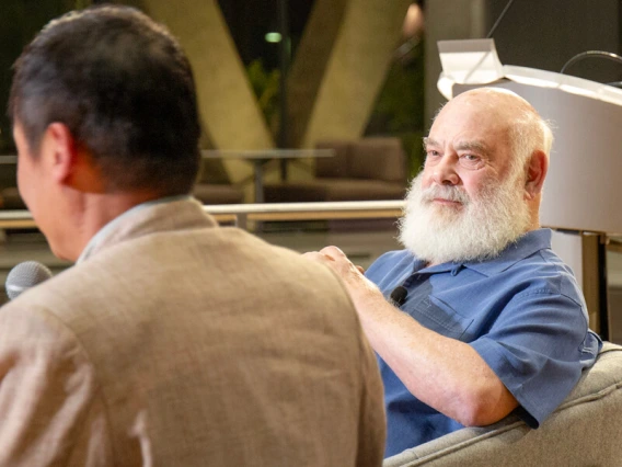 Andrew Weil sitting on stage answering questions