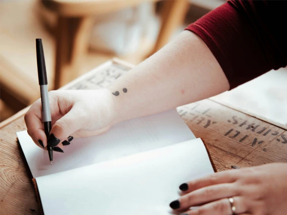 Close up of girl's hands writing in journal