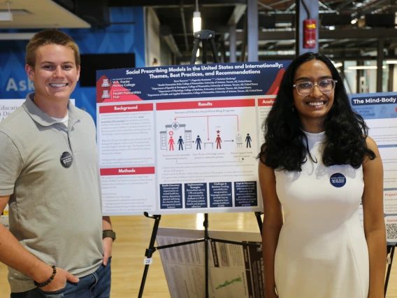Students stand with their research poster on social prescribing