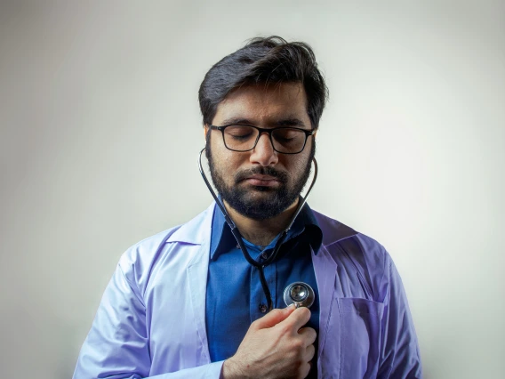 Nurse listens to his own heart with stethescope