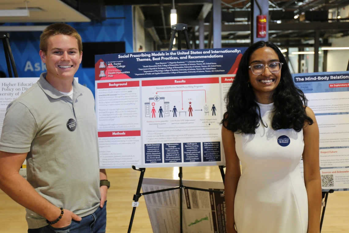 Students stand with their research poster on social prescribing