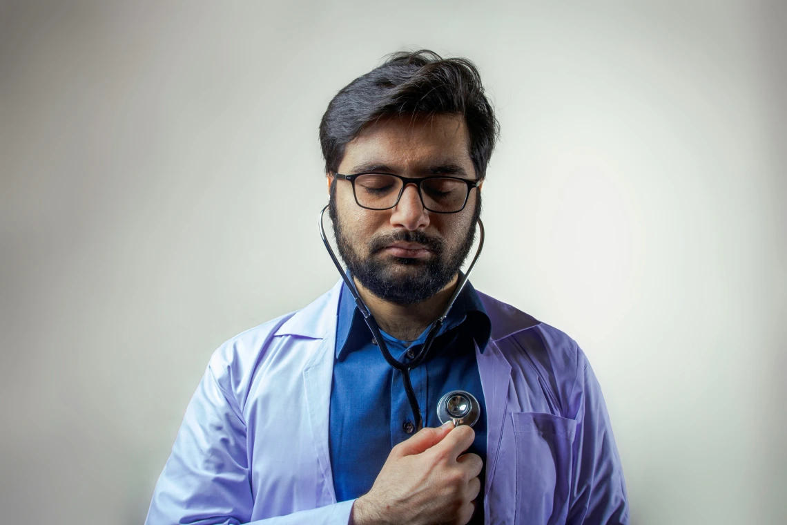Nurse listens to his own heart with stethescope