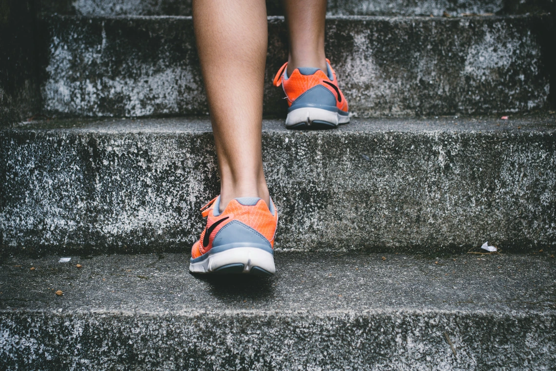 Gray and orange sneakers walking up satirs