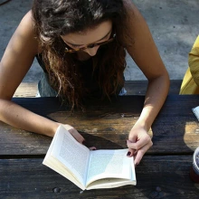 Overhead view of two women writing at a wooden table