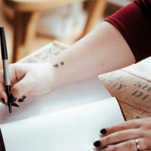 Close up of girl's hands writing in journal