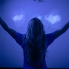 Student with arms outstretched in blue meditation room